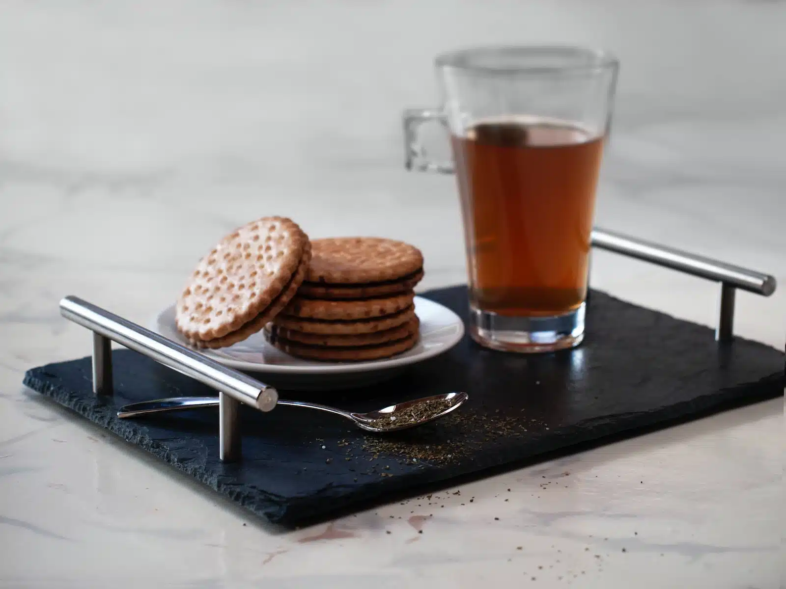 clear glass mug with brown liquid on black wooden table