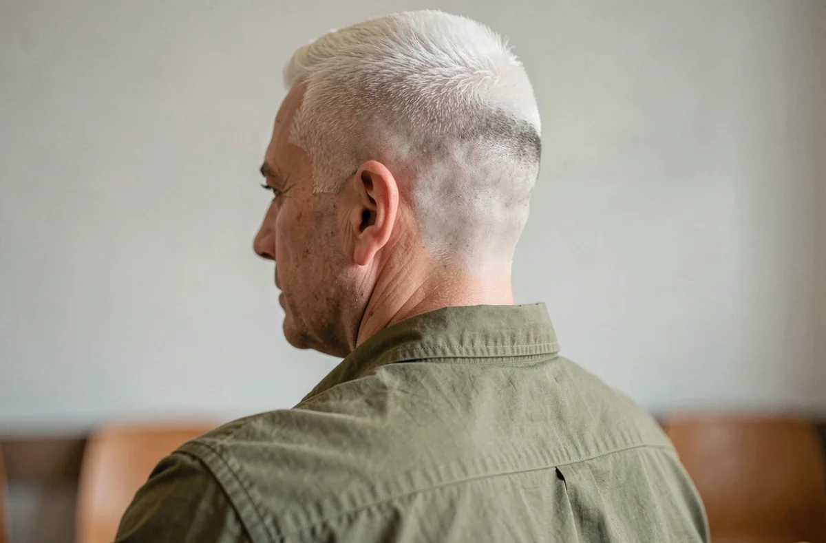 Vue de dos d'un homme aux cheveux gris avec un dégradé blanc impeccable montrant la transition nette vers la peau